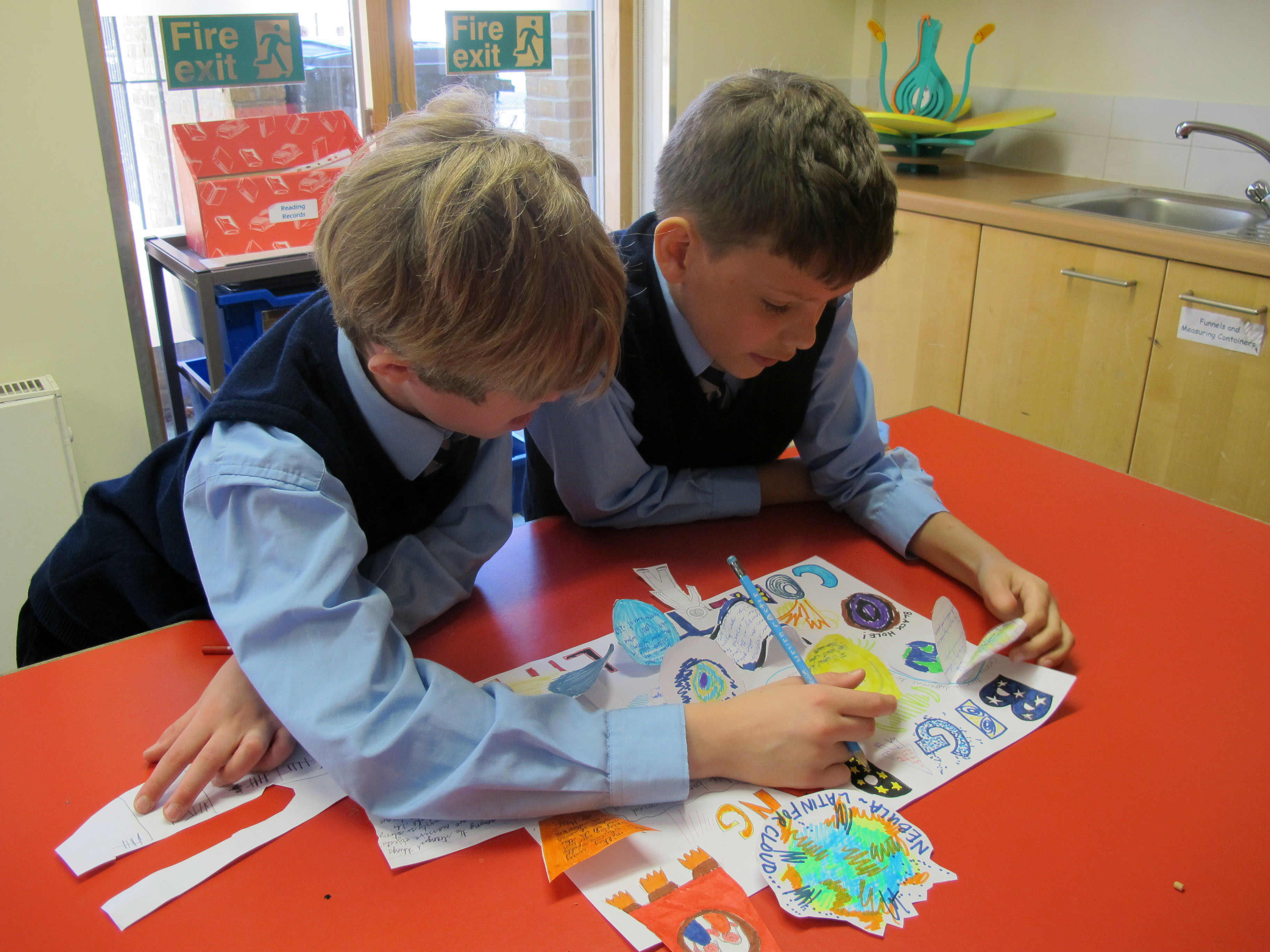 Alex and Harry studying one of the posters produced by Year 5 in their lesson on the Big Bang at Hornsby House School